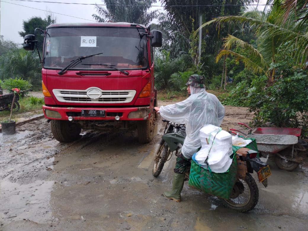 Terjang Hujan Dan Lumpur, Praka HF Manalu Antarkan Nasi Buat Satgas Dan Warga Di Lokasi TMMD